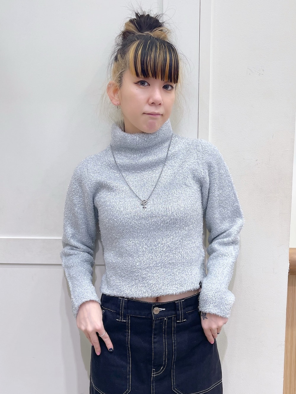 グレー系のニット/セーター、ブラック系のショルダーバッグ、ブラック系のスカートを着用したレディースの秋コーディネートの5枚目の写真