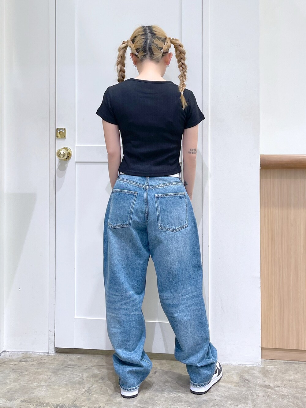 ブルー系のナイロンジャケット、ブラック系のTシャツ/カットソー、ブルー系のデニムパンツを着用したレディースの春コーディネートの4枚目の写真