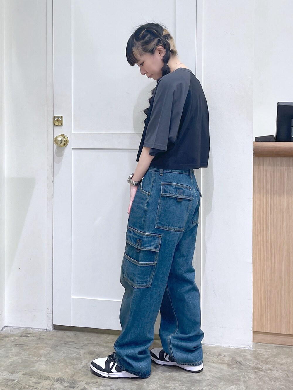 ブラック系のTシャツ/カットソー、ブルー系のカーゴパンツ、グリーン系のタンクトップを着用したレディースの夏コーディネートの3枚目の写真