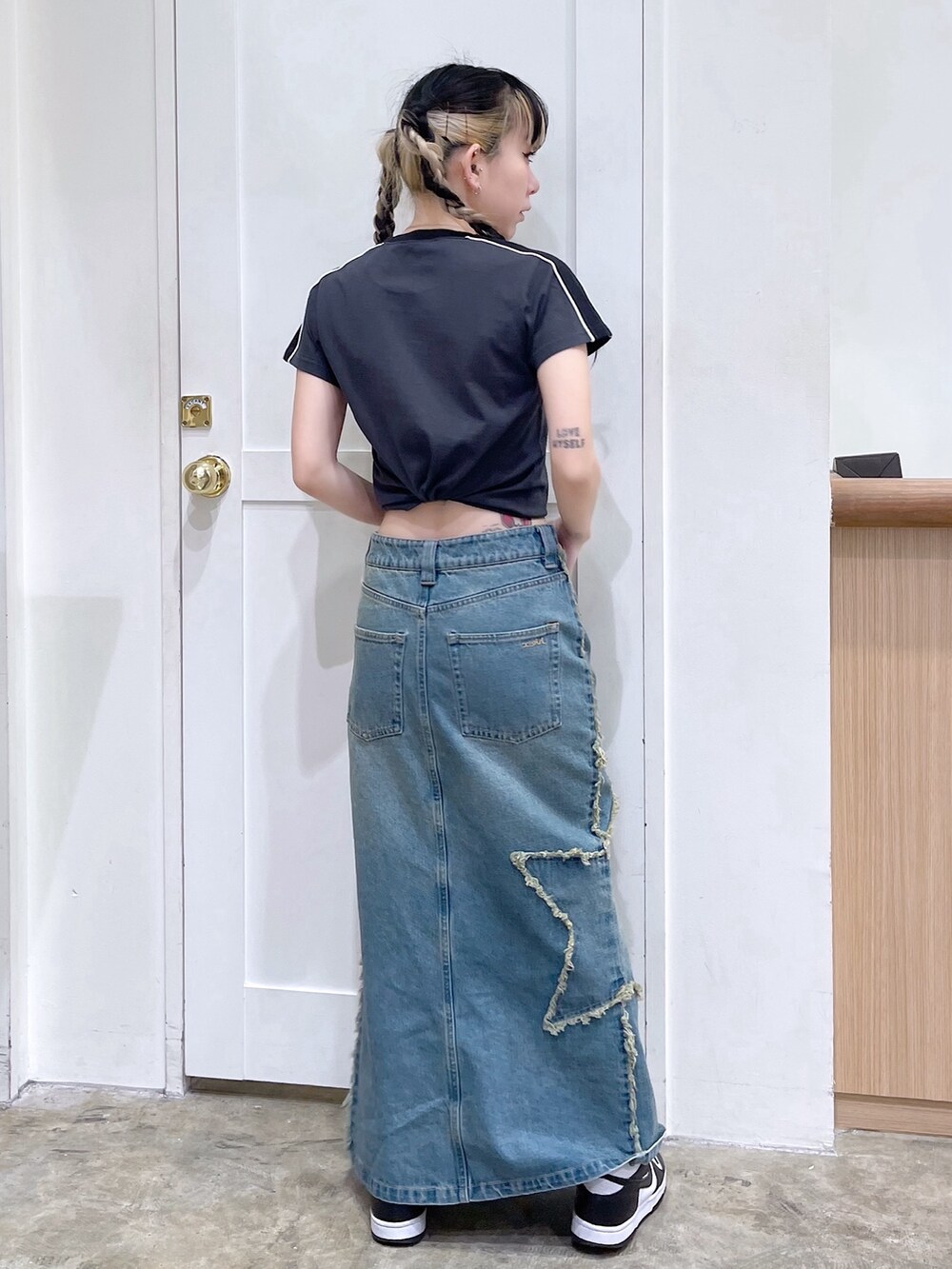 グレー系のTシャツ/カットソー、ブルー系のデニムスカート、ピンク系のショルダーバッグを着用したレディースの春コーディネートの5枚目の写真