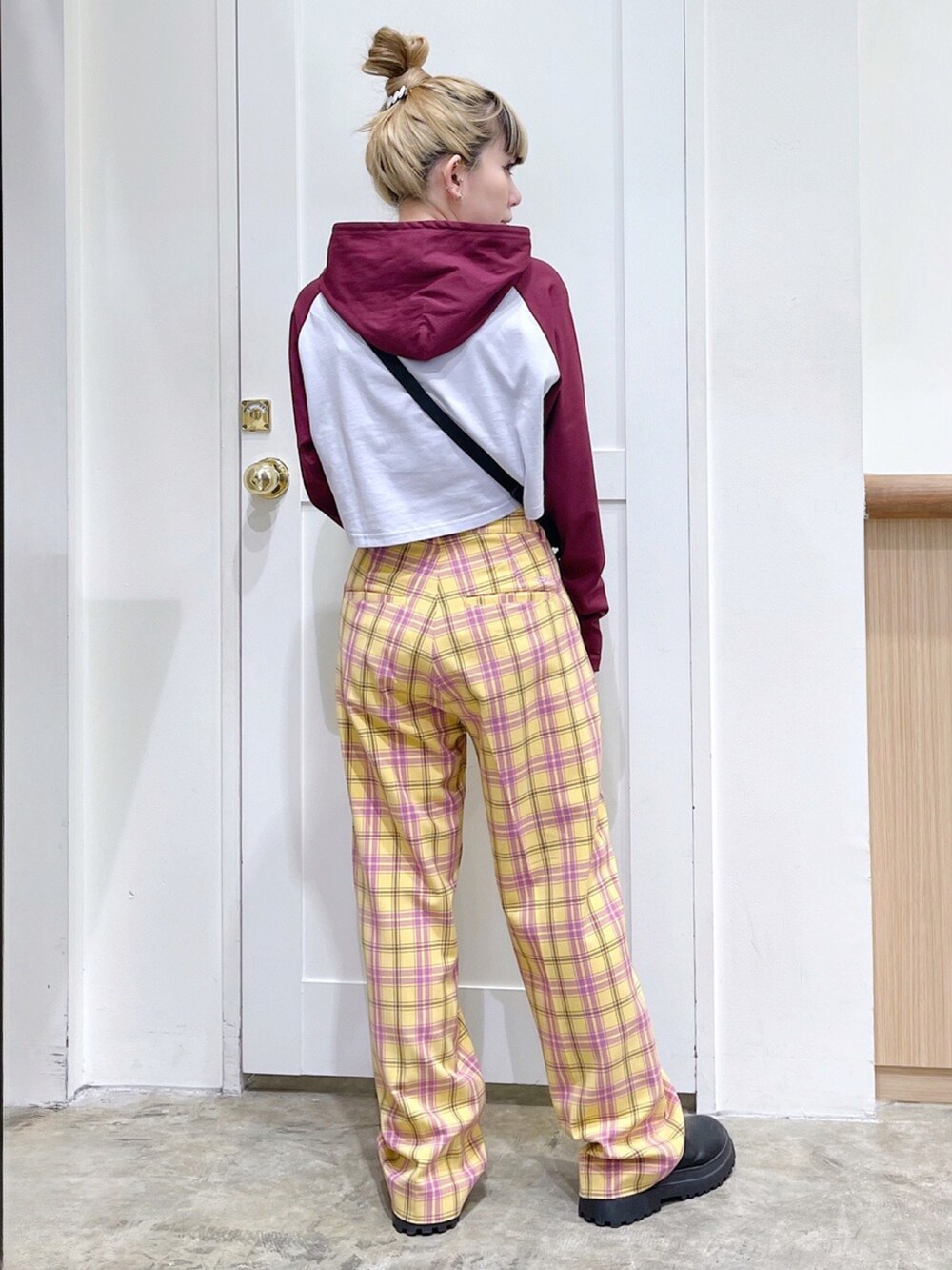 レッド系のパーカー、イエロー系のその他パンツ、その他のショルダーバッグを着用したレディースの冬コーディネートの3枚目の写真