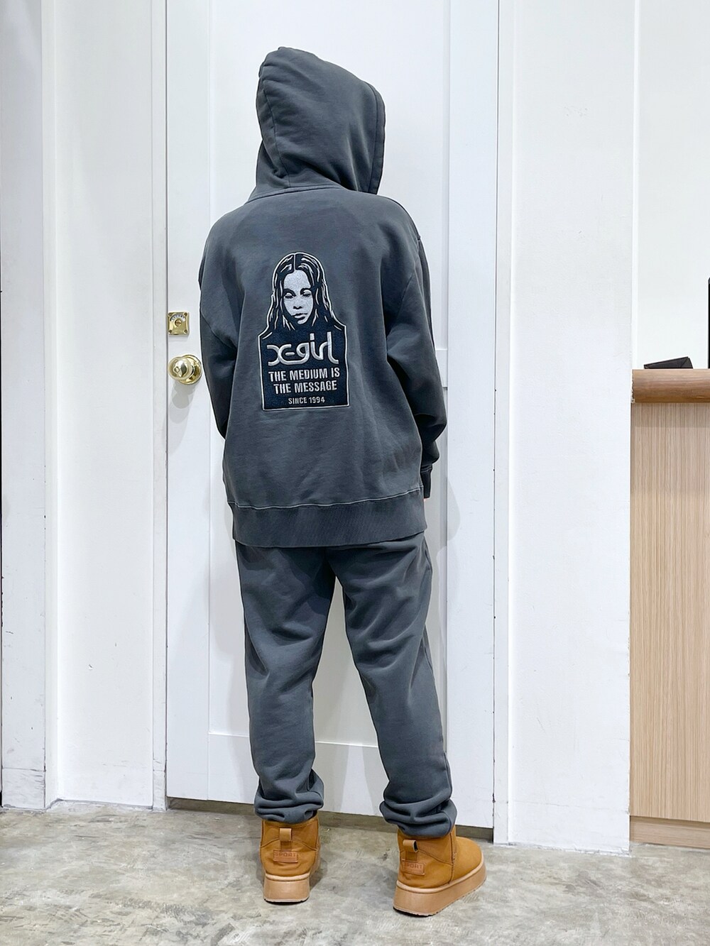 ブラック系のパーカー、ブラック系のスウェットパンツ、ピンク系のTシャツ/カットソーを着用したレディースの冬コーディネートの4枚目の写真