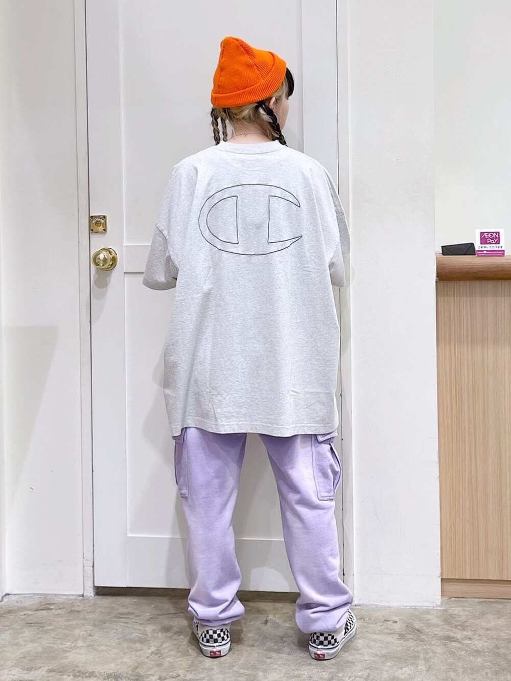 グレー系のワンピース、パープル系のスウェットパンツ、オレンジ系のニットキャップ/ビーニーを着用したレディースの春コーディネートの2枚目の写真