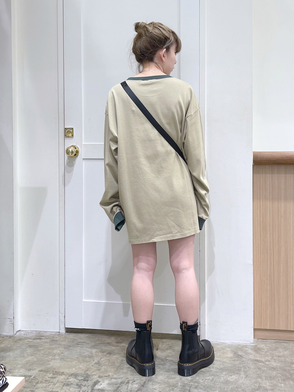 ベージュ系のTシャツ/カットソー、ブラック系のショルダーバッグ、ブラック系のブーツを着用したレディースの夏コーディネートの3枚目の写真