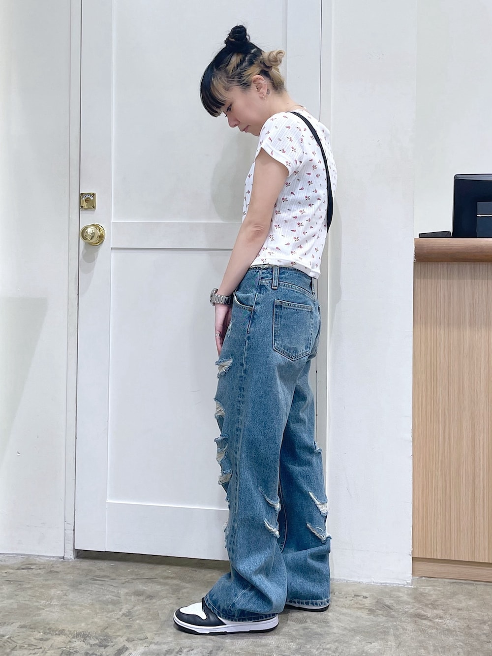 ホワイト系のTシャツ/カットソー、ブルー系のデニムパンツ、ブラック系のショルダーバッグを着用したレディースの夏コーディネートの2枚目の写真