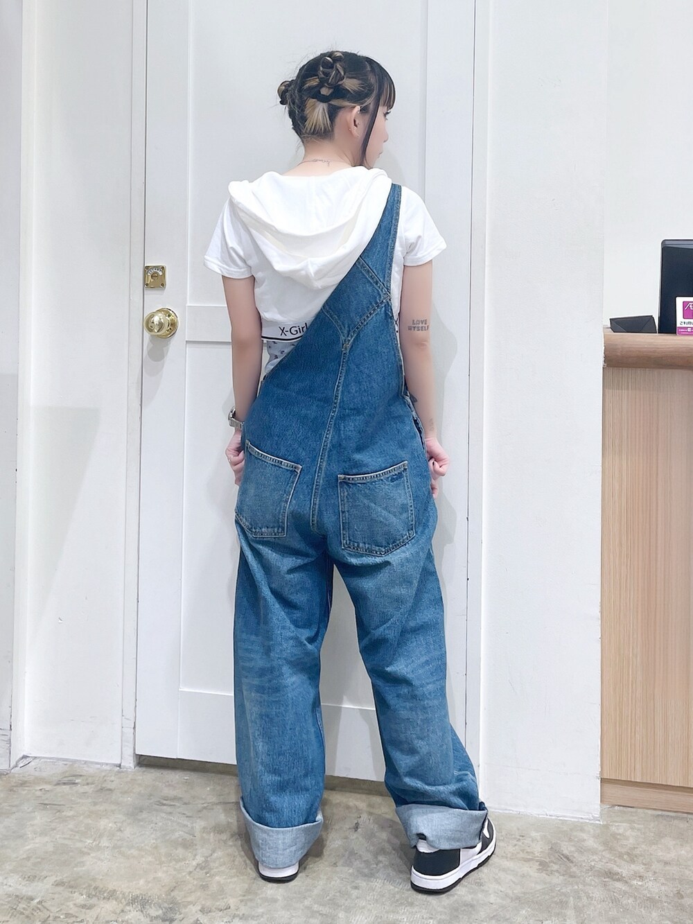 ホワイト系のパーカー、ブルー系のキャミソール、ブルー系のサロペット/オーバーオールを着用したレディースの夏コーディネートの3枚目の写真