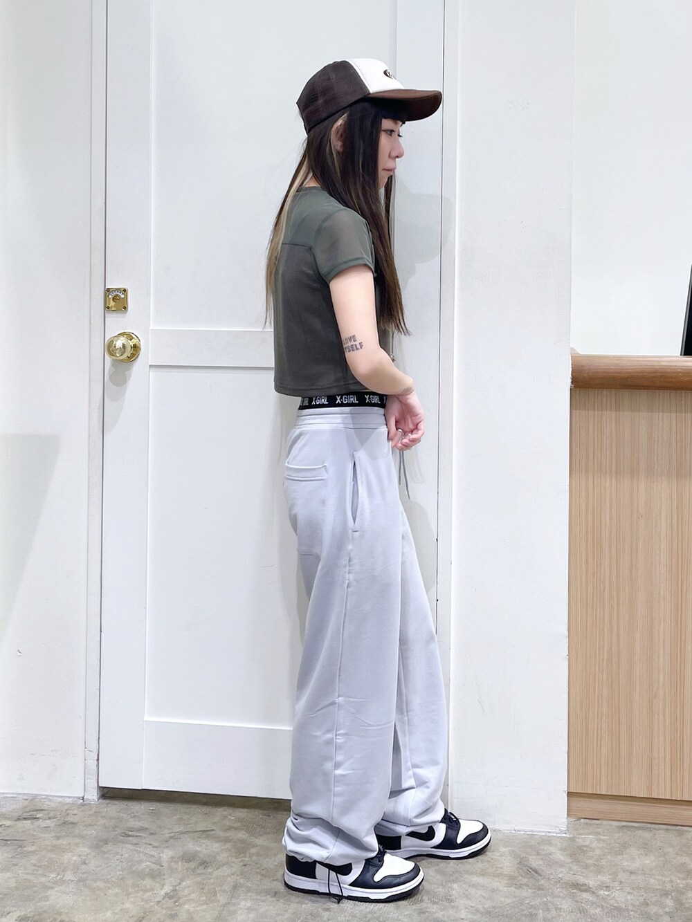 グリーン系のTシャツ/カットソー、グレー系のスウェットパンツ、ブラウン系のキャップを着用したレディースの夏コーディネートの3枚目の写真