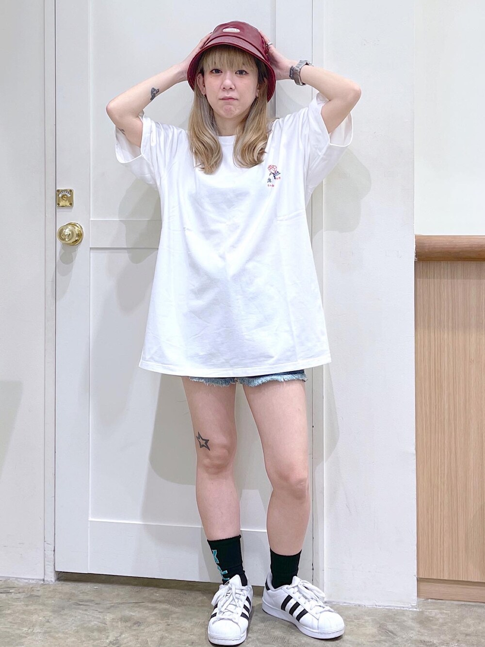 ホワイト系のTシャツ/カットソー、ブルー系のデニムパンツ、レッド系のハットを着用したレディースの夏コーディネートの2枚目の写真