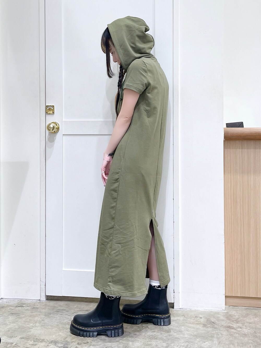 グレー系のトートバッグ、グリーン系のワンピース、ブラック系のブーツを着用したレディースの春コーディネートの4枚目の写真