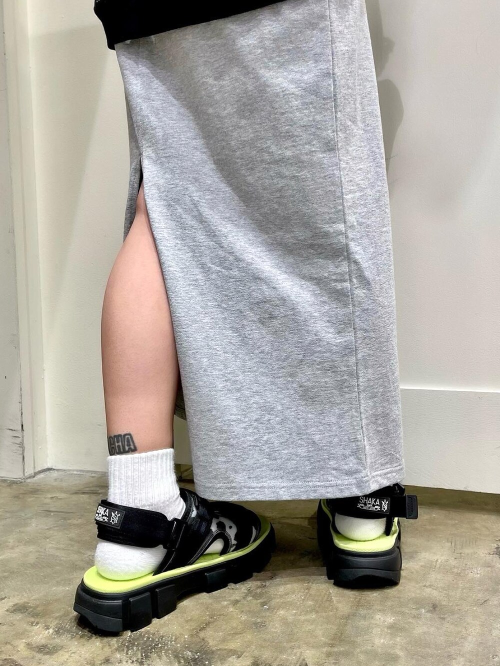 ブラック系のTシャツ/カットソー、グレー系のワンピース、ブラック系のサンダルを着用したレディースの春コーディネートの2枚目の写真