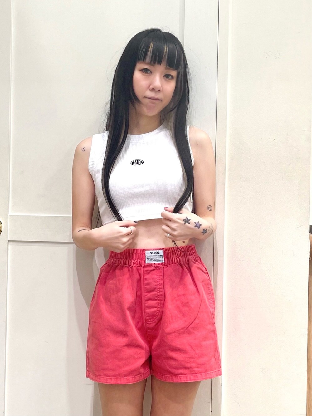 ブラック系のパーカー、ホワイト系のタンクトップ、レッド系のその他パンツを着用したレディースの春コーディネートの5枚目の写真