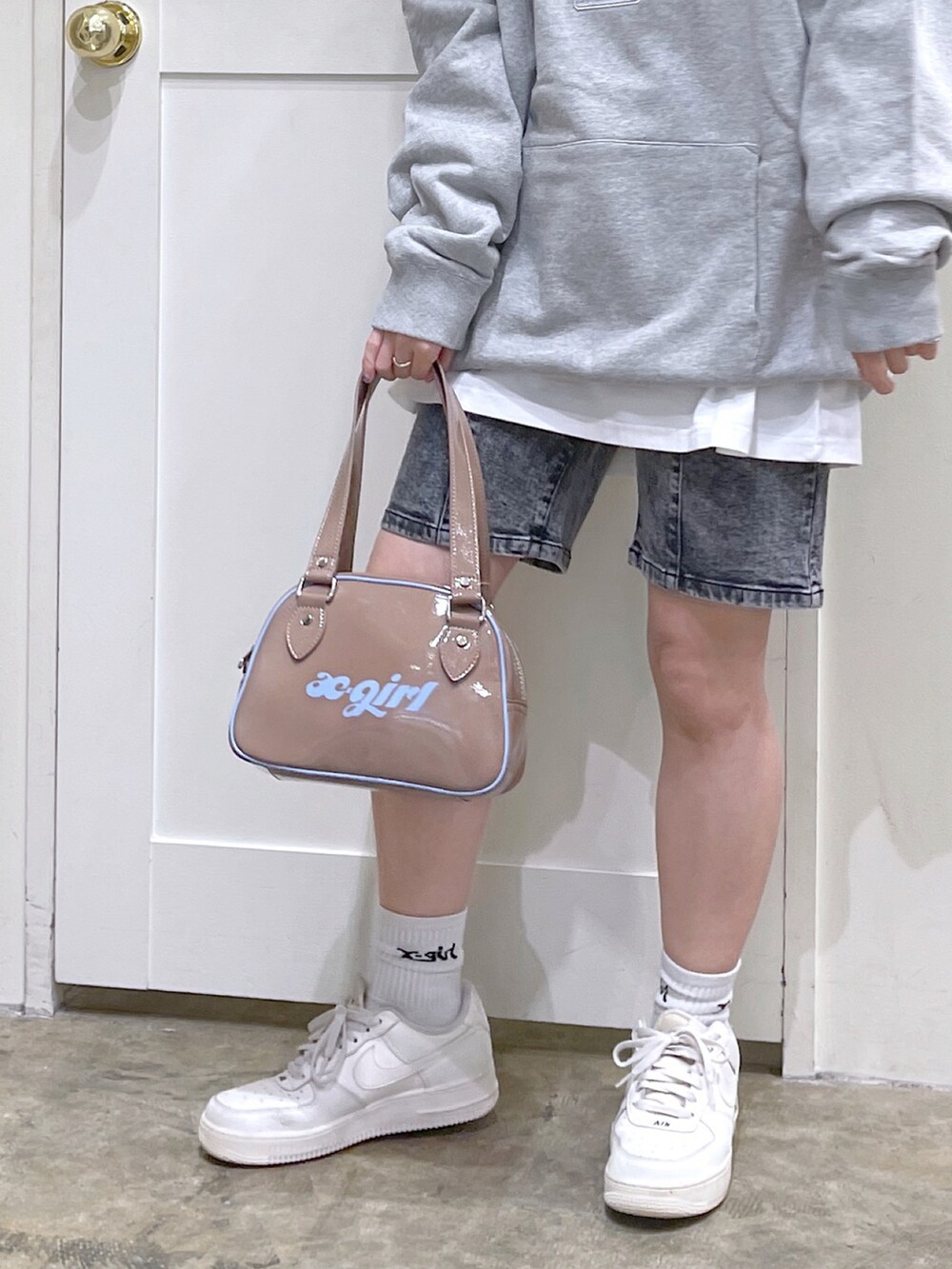 グレー系のパーカー、ホワイト系のTシャツ/カットソー、ブラック系のデニムパンツを着用したレディースの秋コーディネートの3枚目の写真