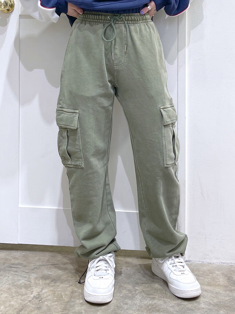 ブルー系のパーカー、レッド系のバックパック/リュック、グリーン系のスウェットパンツを着用したレディースの冬コーディネートの5枚目の写真