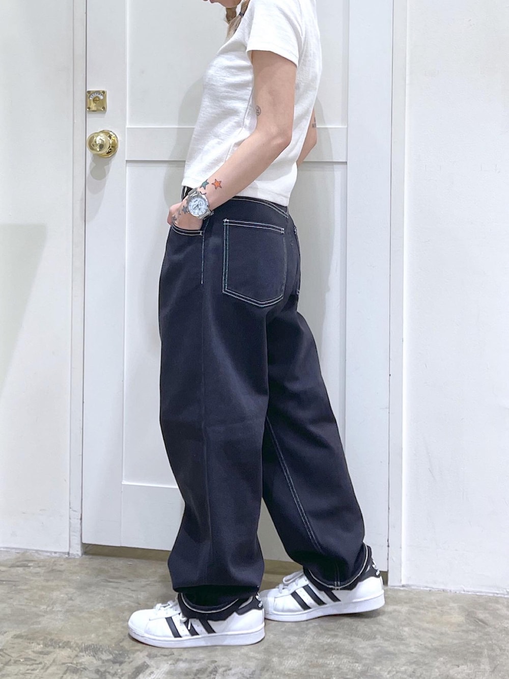 ホワイト系のTシャツ/カットソー、ブラック系のデニムパンツ、ベージュ系のキャスケットを着用したレディースの夏コーディネートの4枚目の写真