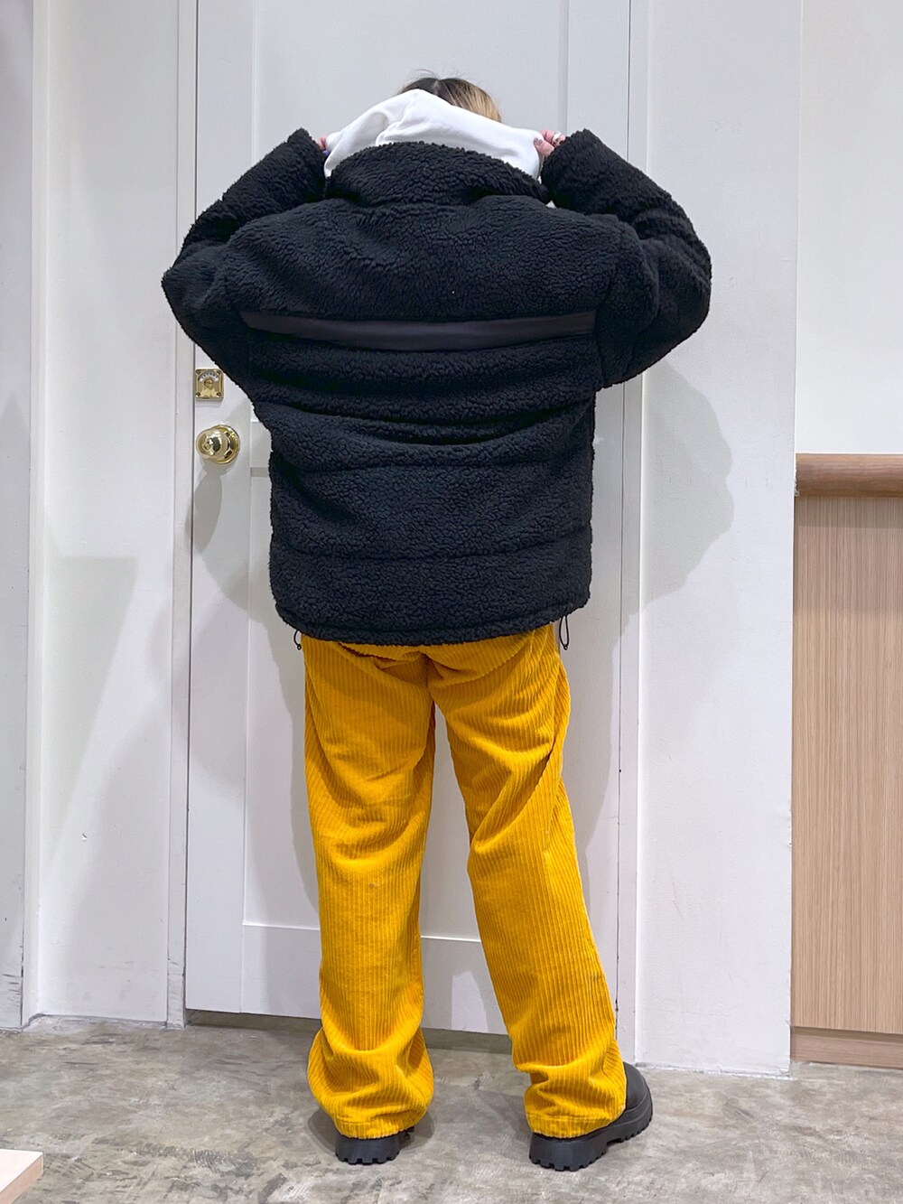 ブラック系のその他アウター、ホワイト系のパーカー、イエロー系のその他パンツを着用したレディースの冬コーディネートの3枚目の写真