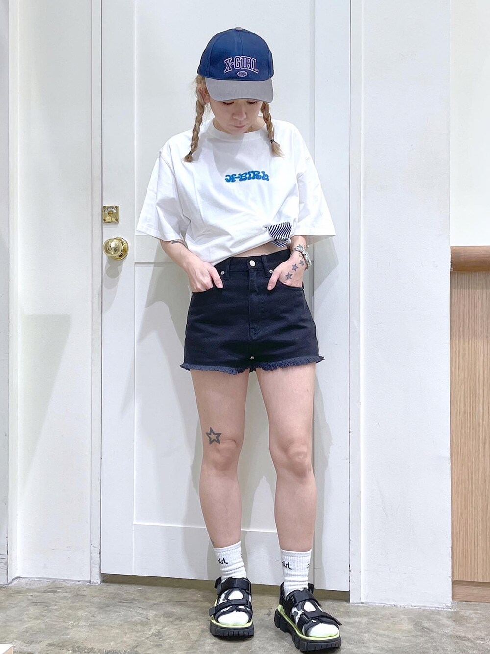 ホワイト系のTシャツ/カットソー、ブラック系のデニムパンツ、ブラック系のサンダルを着用したレディースの夏コーディネートの2枚目の写真