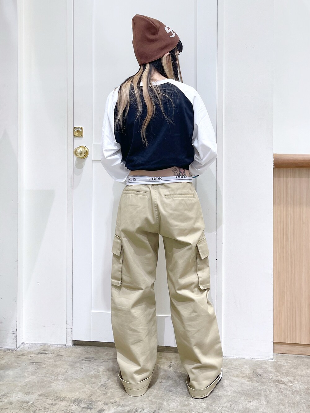 ブラック系のTシャツ/カットソー、ベージュ系のチノパンツ、ブラウン系のニットキャップ/ビーニーを着用したレディースの夏コーディネートの4枚目の写真