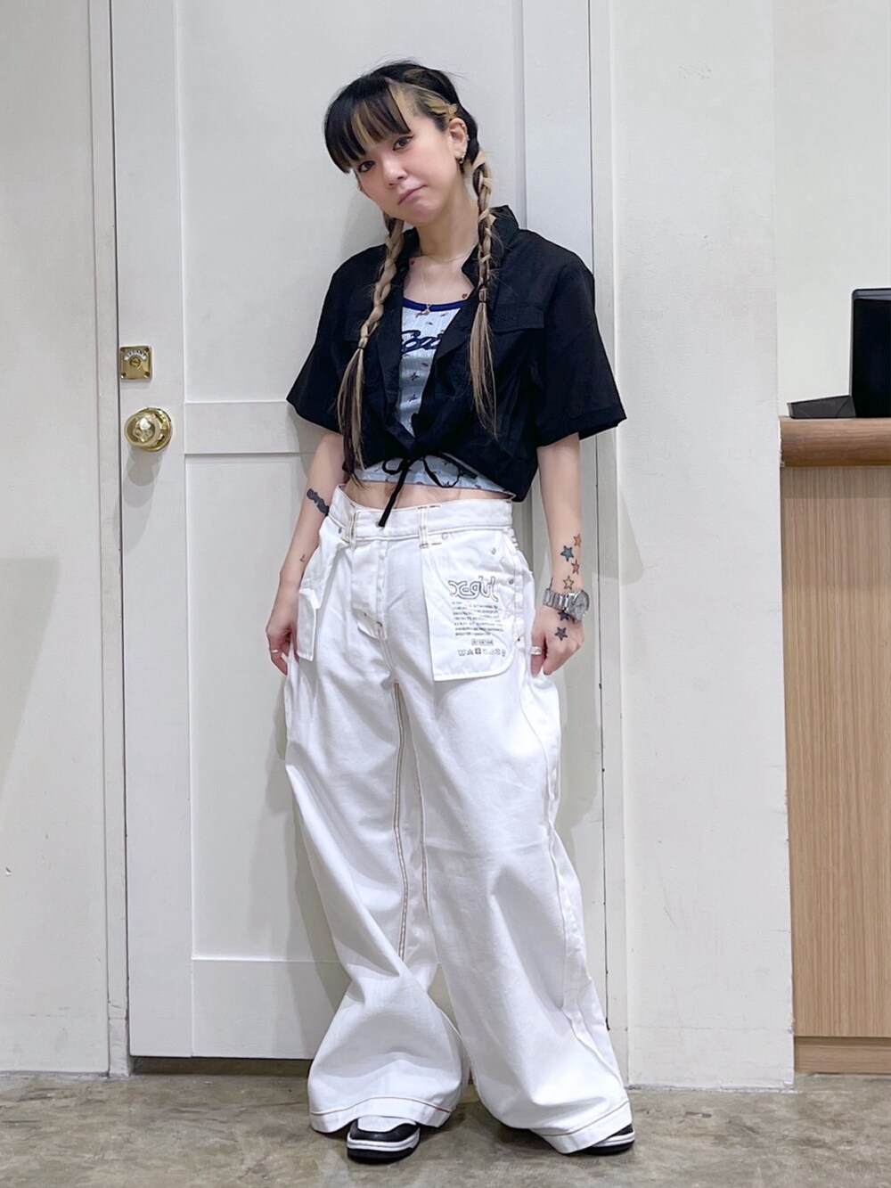 ブラック系のシャツ/ブラウス、ブルー系のキャミソール、ホワイト系のデニムパンツを着用したレディースの春コーディネートの2枚目の写真