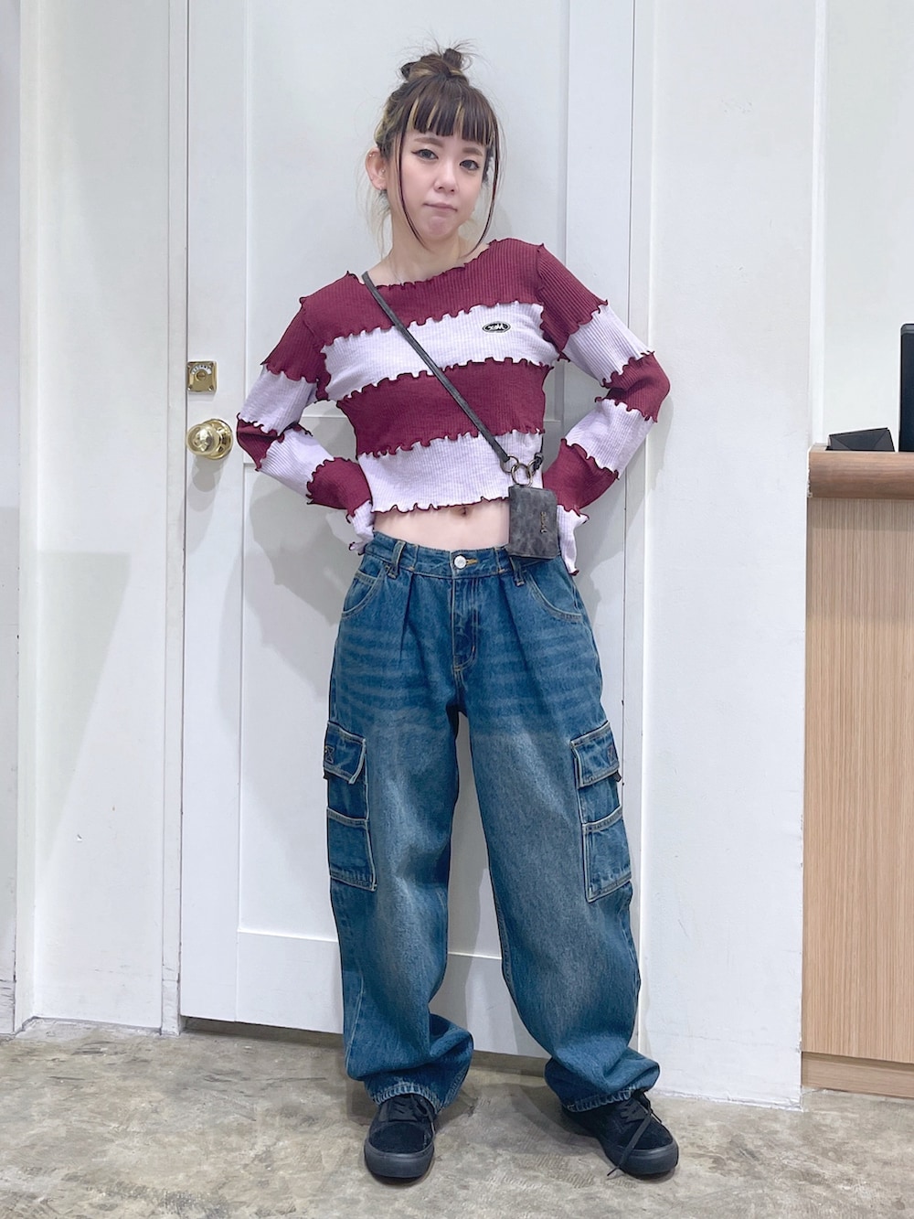 レッド系のTシャツ/カットソー、ブルー系のカーゴパンツ、ゴールド系のコインケースを着用したレディースの秋コーディネートの2枚目の写真