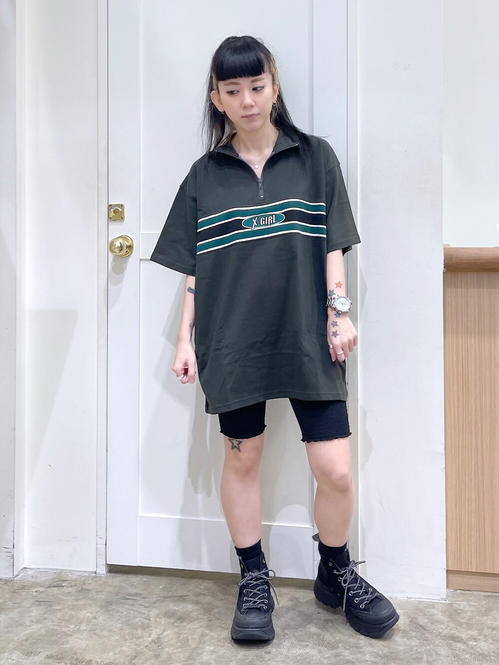 グレー系のワンピース、ピンク系のショルダーバッグ、ブラック系のスニーカーを着用したレディースの夏コーディネートの2枚目の写真