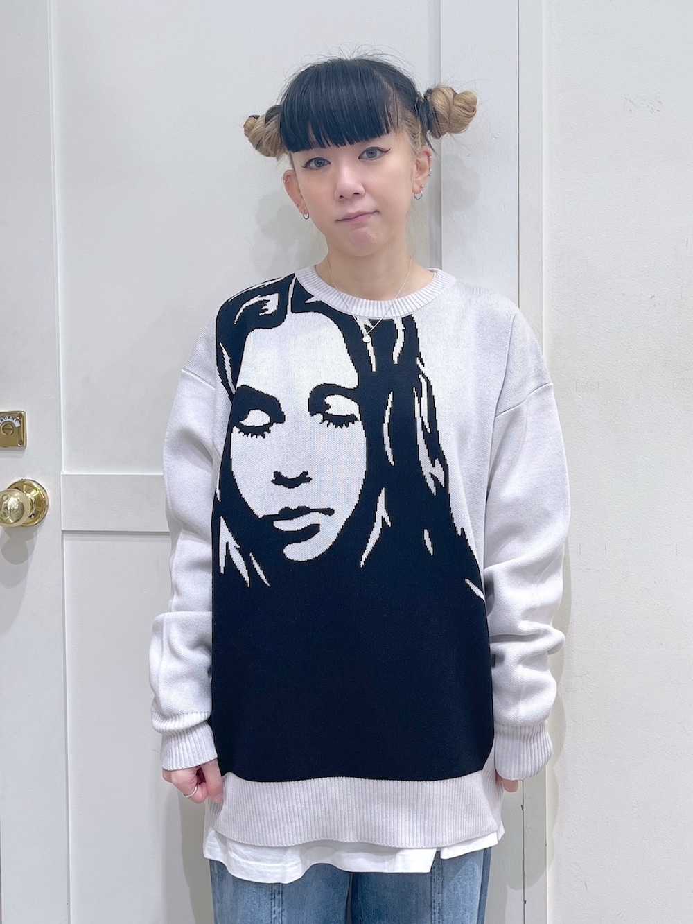 ホワイト系のニット/セーター、ブラック系のショルダーバッグ、ブルー系のデニムパンツを着用したレディースの秋コーディネートの4枚目の写真