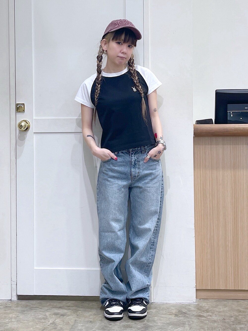 ブラック系のTシャツ/カットソー、ブルー系のデニムパンツ、レッド系のキャップを着用したレディースの夏コーディネートの5枚目の写真