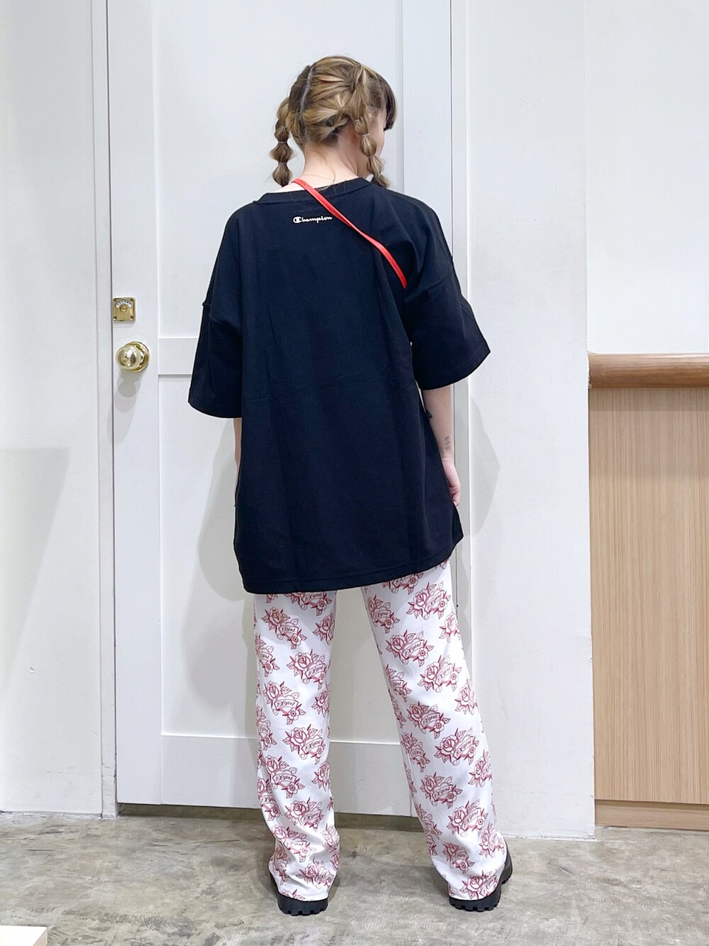 ブラック系のTシャツ/カットソー、ホワイト系のその他パンツ、レッド系のコインケースを着用したレディースの春コーディネートの3枚目の写真