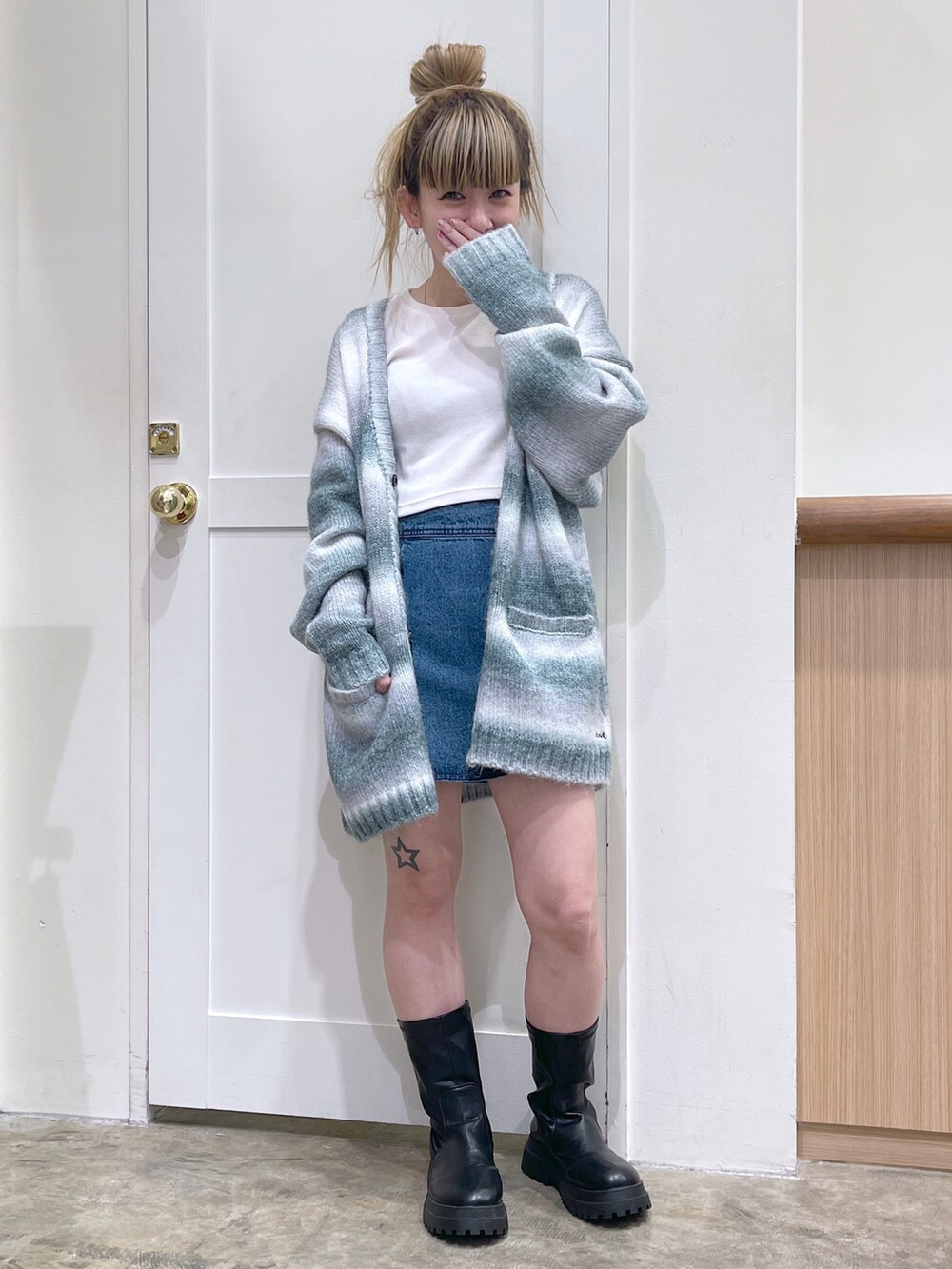 グレー系のカーディガン/ボレロ、ホワイト系のTシャツ/カットソー、ブルー系のデニムスカートを着用したレディースの秋コーディネートの5枚目の写真