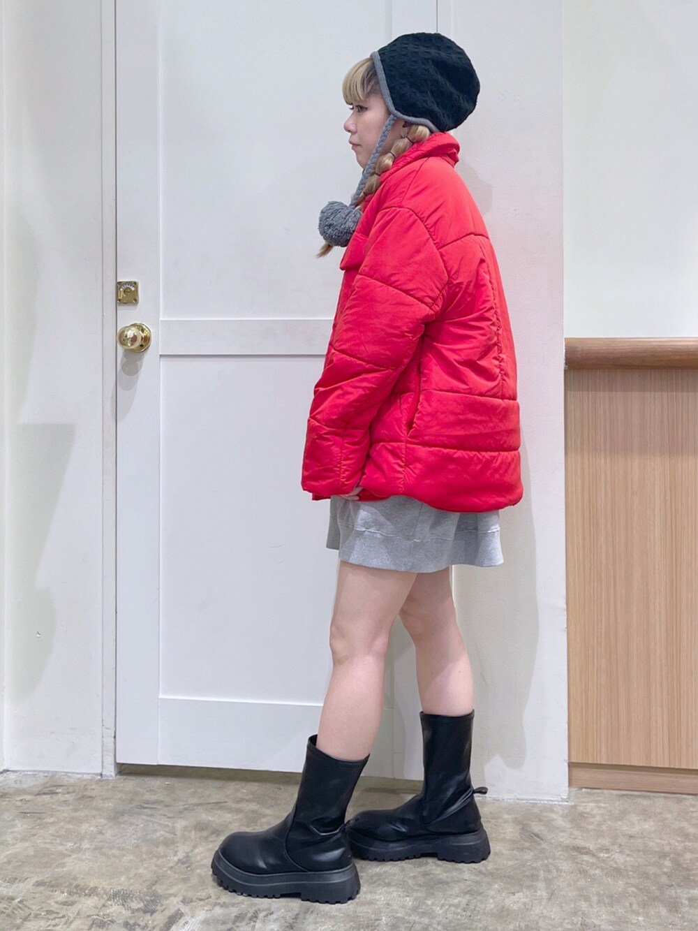 レッド系のその他アウター、グレー系のスウェット、ブラック系のニットキャップ/ビーニーを着用したレディースの冬コーディネートの2枚目の写真