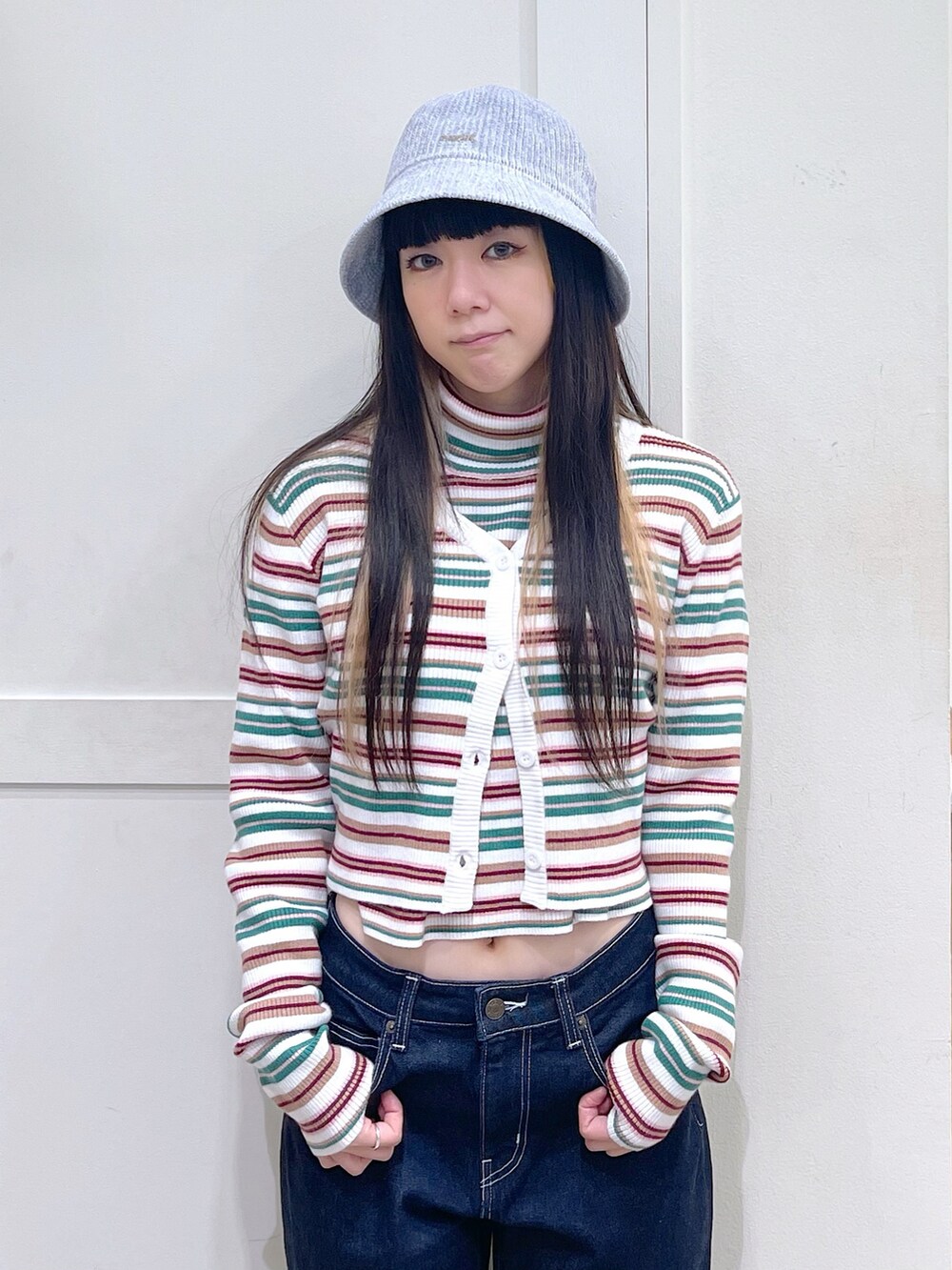 ホワイト系のカーディガン/ボレロ、ホワイト系のニット/セーター、ブルー系のデニムパンツを着用したレディースの秋コーディネートの4枚目の写真