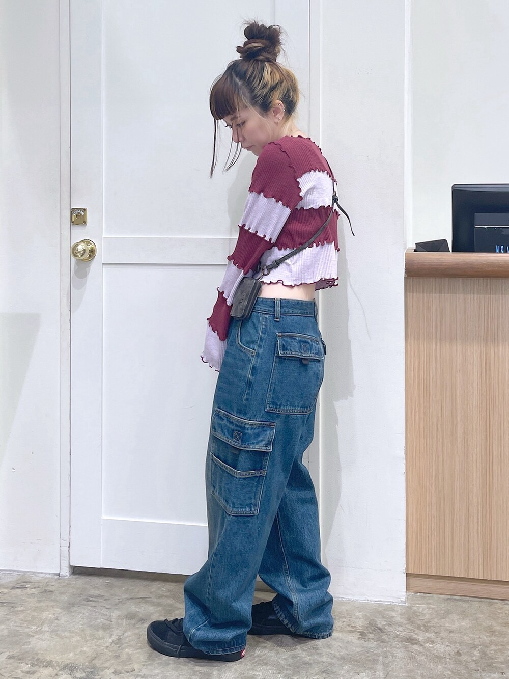 レッド系のTシャツ/カットソー、ブルー系のカーゴパンツ、ゴールド系のコインケースを着用したレディースの秋コーディネートの3枚目の写真