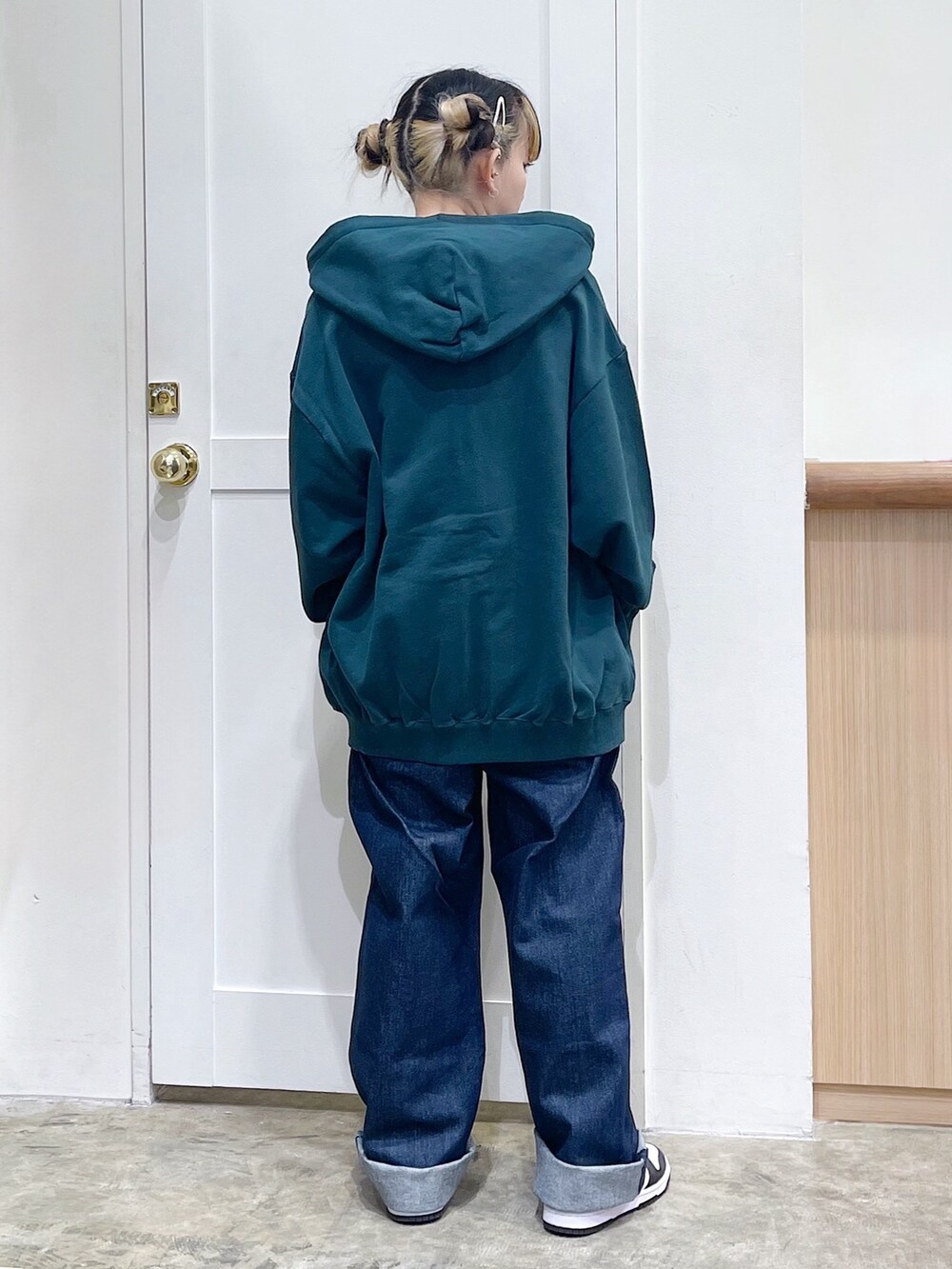 グリーン系のパーカー、ブルー系のサロペット/オーバーオール、ブラウン系のTシャツ/カットソーを着用したレディースの冬コーディネートの4枚目の写真