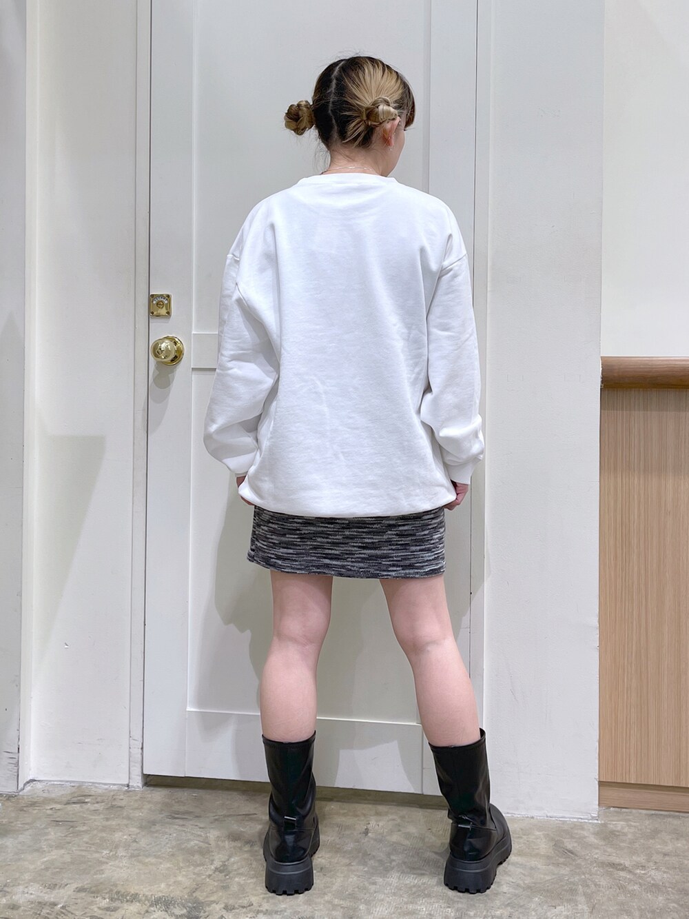 ホワイト系のスウェット、ブラック系のスカート、イエロー系のショルダーバッグを着用したレディースの冬コーディネートの4枚目の写真