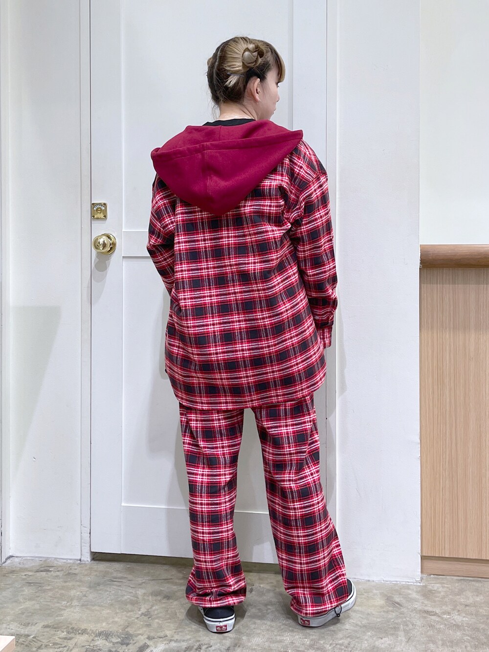 レッド系のシャツ/ブラウス、ブラック系のニット/セーター、ホワイト系のトートバッグを着用したレディースの秋コーディネートの3枚目の写真