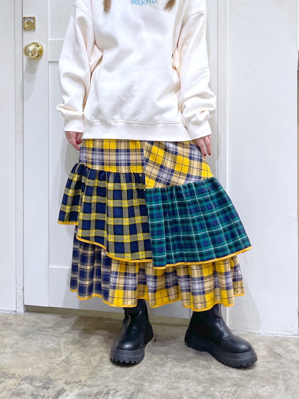 ホワイト系のスウェット、イエロー系のスカート、ベージュ系のキャップを着用したレディースの秋コーディネートの5枚目の写真