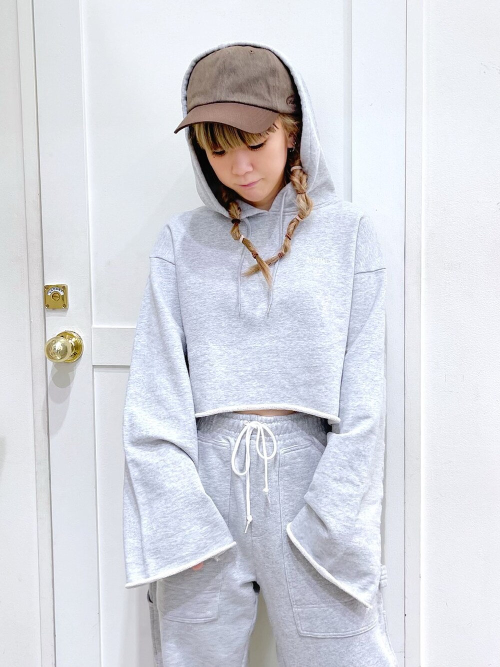 グレー系のパーカー、グレー系のスウェットパンツ、ブラウン系のキャップを着用したレディースの冬コーディネートの4枚目の写真