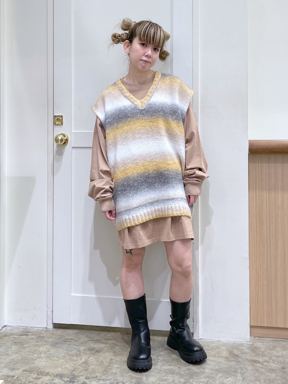 ベージュ系のワンピース、イエロー系のベスト、ホワイト系のショルダーバッグを着用したレディースの秋コーディネートの2枚目の写真