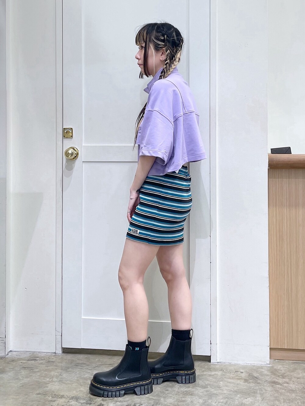 パープル系のスウェット、ブラック系のワンピース、ホワイト系のショルダーバッグを着用したレディースの春コーディネートの2枚目の写真