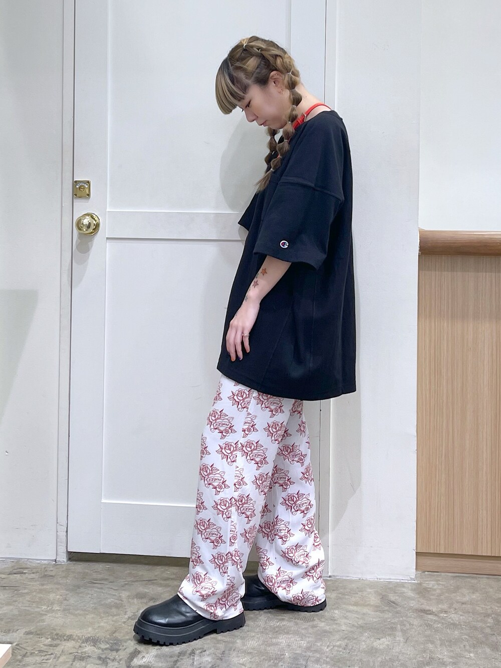 ブラック系のTシャツ/カットソー、ホワイト系のその他パンツ、レッド系のコインケースを着用したレディースの春コーディネートの2枚目の写真