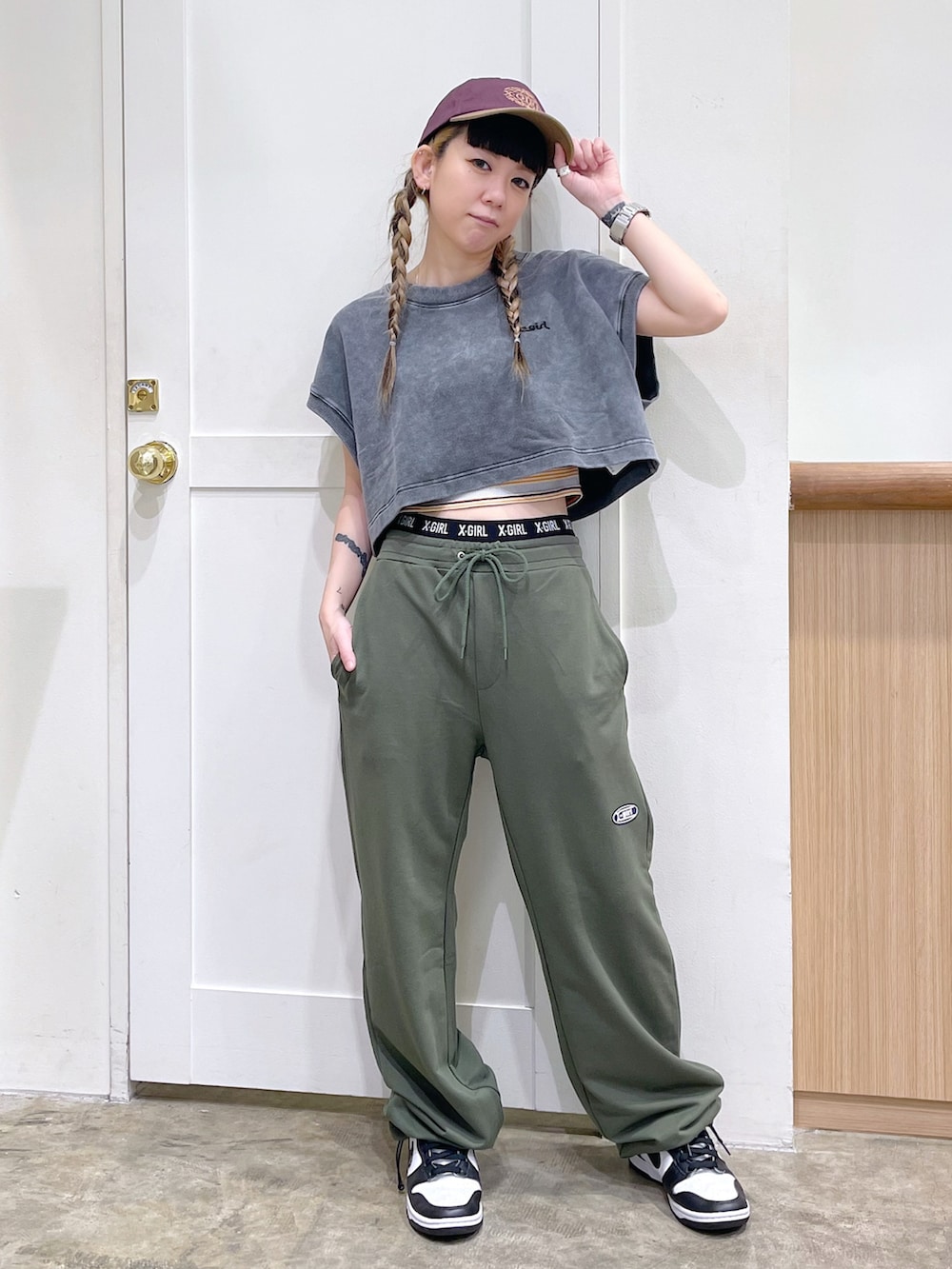 グレー系のタンクトップ、ブラウン系のキャミソール、グリーン系のスウェットパンツを着用したレディースの夏コーディネートの2枚目の写真