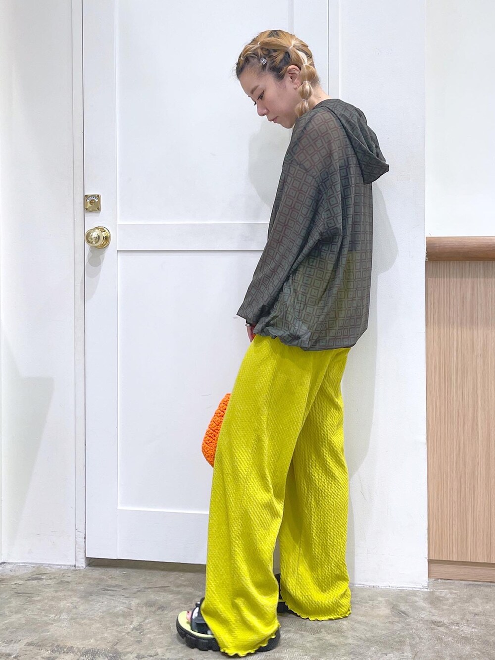 グリーン系のパーカー、ブラック系のタンクトップ、グリーン系のその他パンツを着用したレディースの夏コーディネートの3枚目の写真