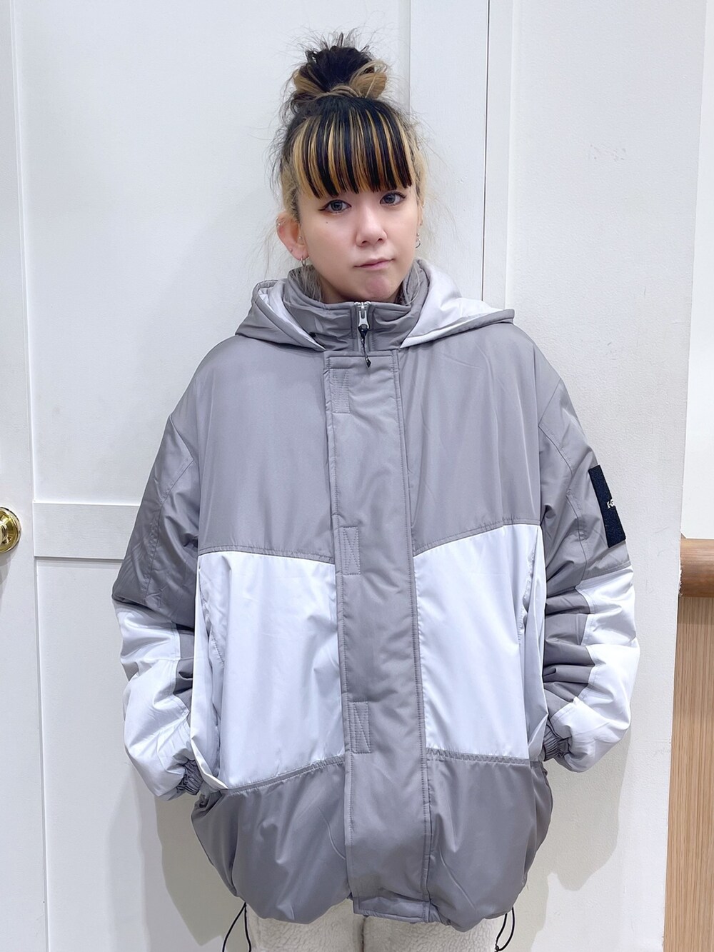 グレー系のマウンテンパーカー、ブラック系のスウェット、ホワイト系のその他パンツを着用したレディースの秋コーディネートの2枚目の写真
