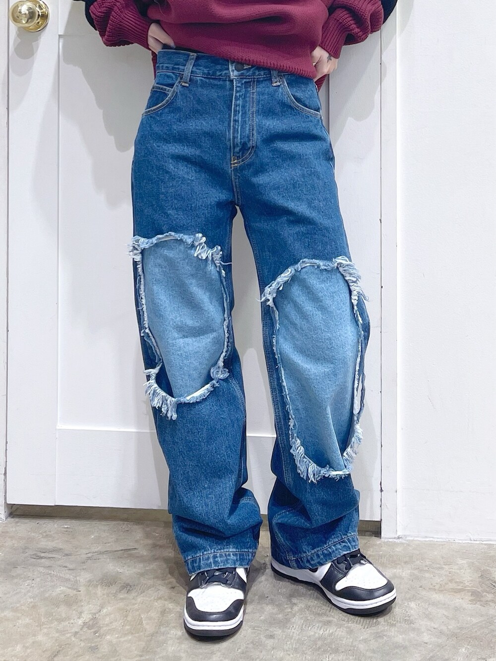 レッド系のニット/セーター、ブルー系のデニムパンツ、ホワイト系のマフラーを着用したレディースの冬コーディネートの5枚目の写真