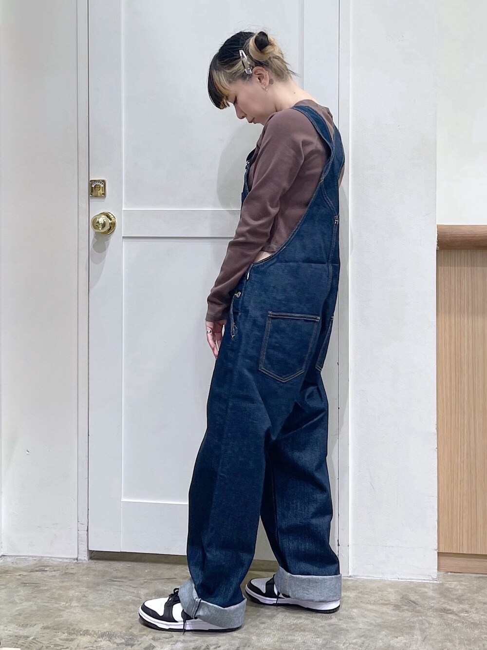 グリーン系のパーカー、ブルー系のサロペット/オーバーオール、ブラウン系のTシャツ/カットソーを着用したレディースの冬コーディネートの6枚目の写真