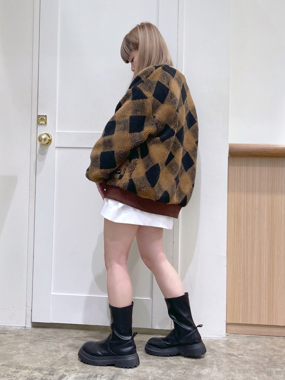 ブラウン系のカーディガン/ボレロ、ホワイト系のスウェット、レッド系のボストンバッグを着用したレディースの冬コーディネートの2枚目の写真