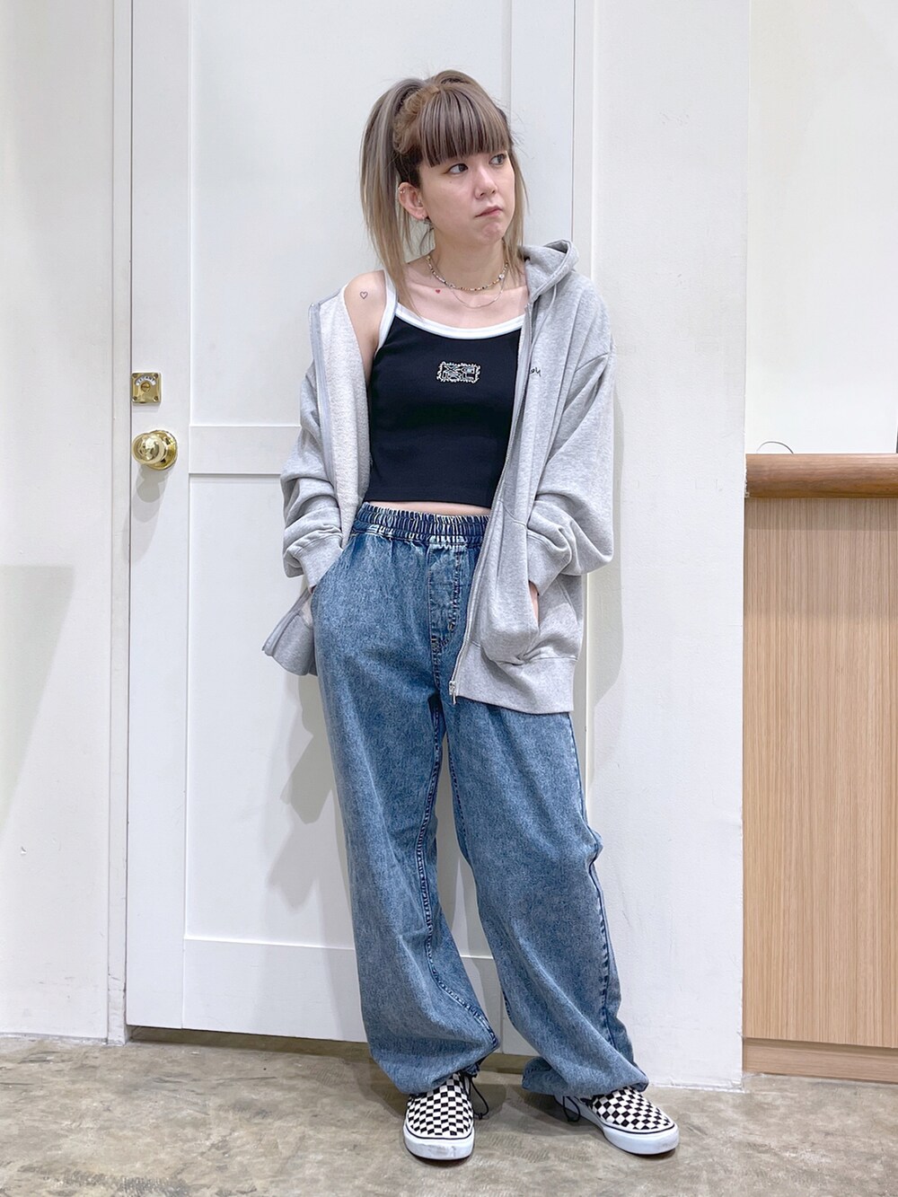 グレー系のパーカー、ブラック系のキャミソール、ブルー系のデニムパンツを着用したレディースの夏コーディネートの2枚目の写真