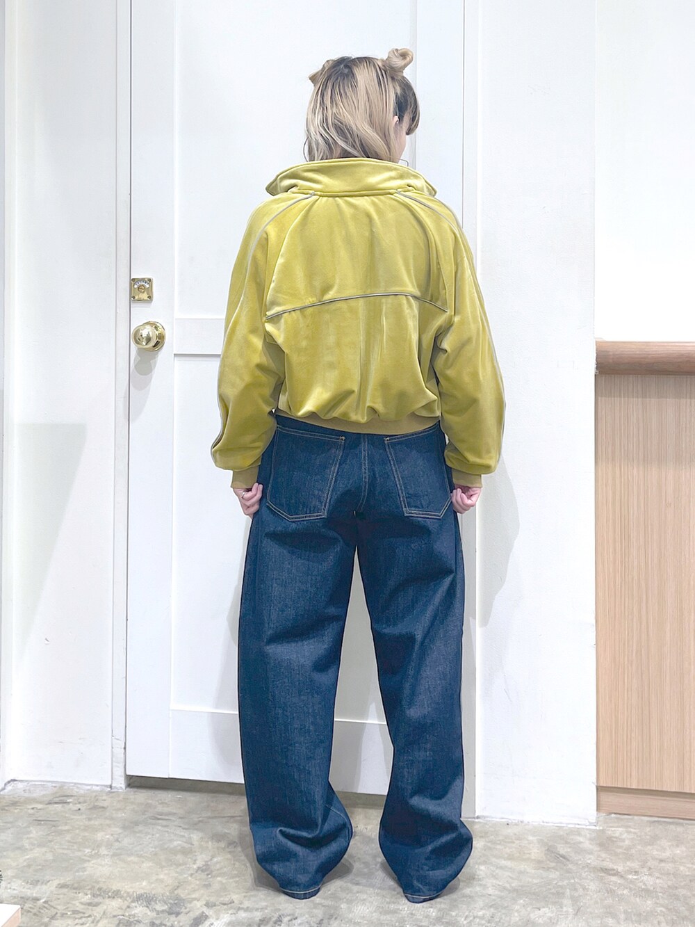 イエロー系のスウェット、ホワイト系のTシャツ/カットソー、ブルー系のデニムパンツを着用したレディースの秋コーディネートの3枚目の写真