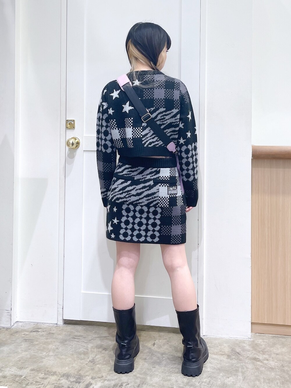 ブラック系のカーディガン/ボレロ、ブラック系のスカート、パープル系のショルダーバッグを着用したレディースの秋コーディネートの3枚目の写真