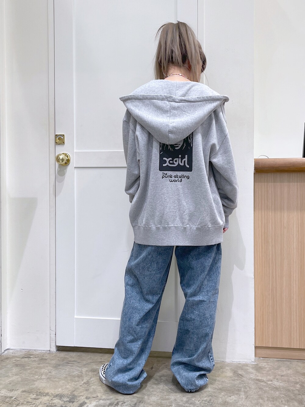 グレー系のパーカー、ブラック系のキャミソール、ブルー系のデニムパンツを着用したレディースの夏コーディネートの5枚目の写真