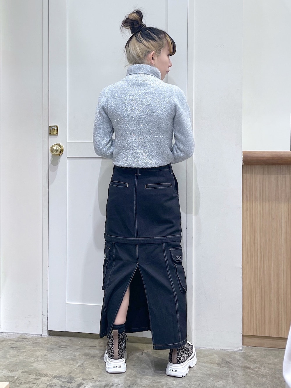 グレー系のニット/セーター、ブラック系のショルダーバッグ、ブラック系のスカートを着用したレディースの秋コーディネートの4枚目の写真